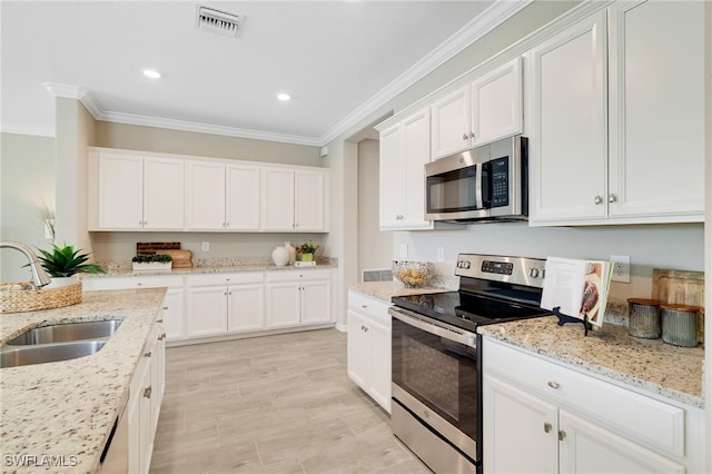 19694 Deming Ln, Estero, FL 33928 - kitchen featuring appliances with stainless steel finishes, ornamental molding, white cabinetry, recessed lighting, and light stone countertops