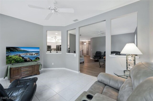 1340 Charleston Square Dr Unit 101, Naples, FL 34110 - living room with a ceiling fan, light tile patterned flooring, and baseboards