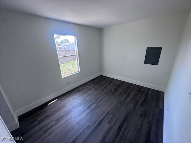 5981 Cubles Dr, Bokeelia, FL 33922 - spare room featuring electric panel, dark wood-style flooring, and baseboards