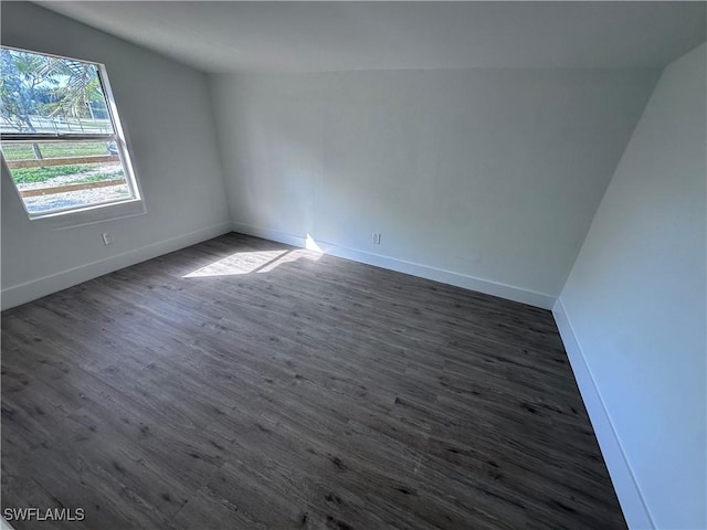 5981 Cubles Dr, Bokeelia, FL 33922 - unfurnished room with baseboards, vaulted ceiling, and dark wood finished floors