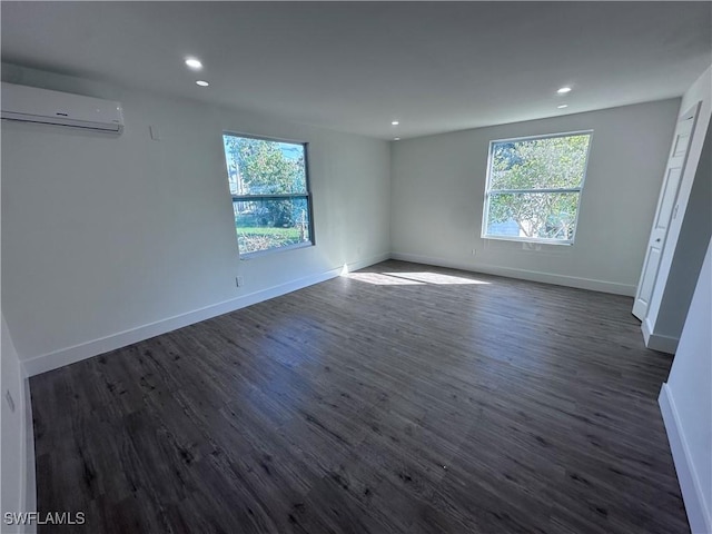 5981 Cubles Dr, Bokeelia, FL 33922 - unfurnished room with a wall mounted air conditioner, dark wood-style flooring, baseboards, and recessed lighting