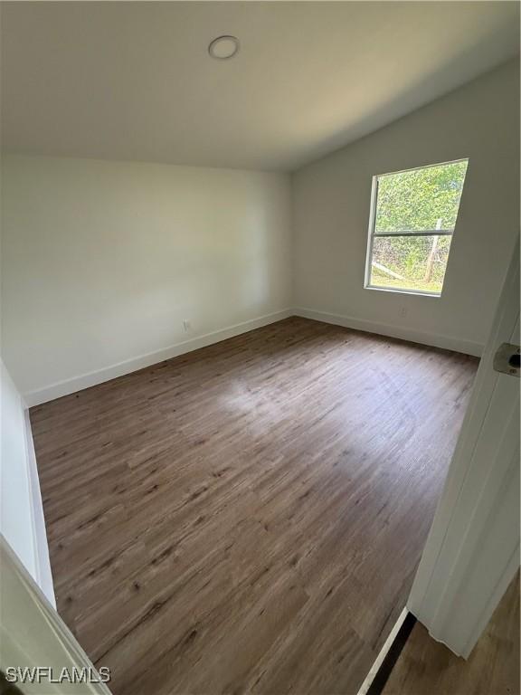 5981 Cubles Dr, Bokeelia, FL 33922 - spare room featuring dark wood finished floors and lofted ceiling