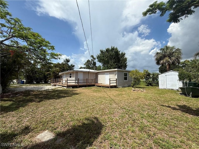 5981 Cubles Dr, Bokeelia, FL 33922 - view of grassy yard featuring a wooden deck and a storage shed