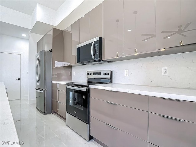 323 NE 19th Ter, Cape Coral, FL 33909 - kitchen with appliances with stainless steel finishes, gray cabinetry, decorative backsplash, and modern cabinets
