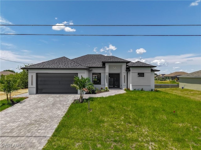 323 NE 19th Ter, Cape Coral, FL 33909 - prairie-style house with a garage, stucco siding, a front lawn, and decorative driveway