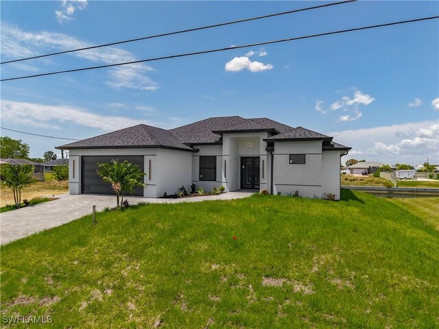 323 NE 19th Ter, Cape Coral, FL 33909 - prairie-style home with an attached garage, decorative driveway, stucco siding, and a front yard
