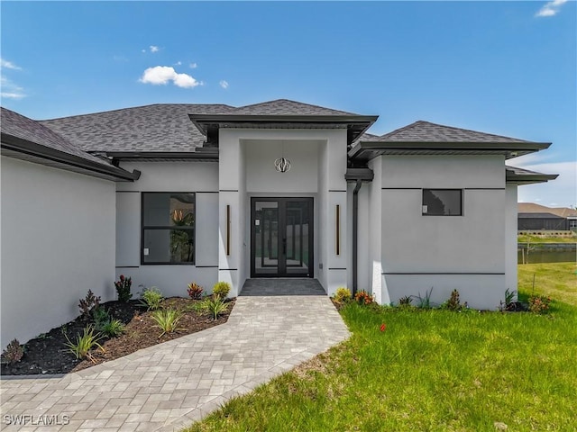323 NE 19th Ter, Cape Coral, FL 33909 - entrance to property featuring french doors, stucco siding, and roof with shingles