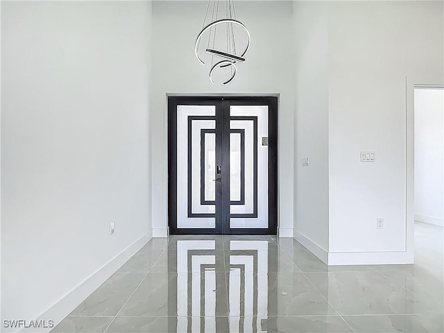 323 NE 19th Ter, Cape Coral, FL 33909 - entrance foyer with baseboards, marble finish flooring, and a chandelier