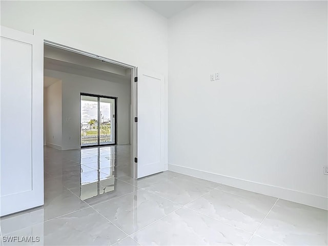 323 NE 19th Ter, Cape Coral, FL 33909 - empty room featuring baseboards and light marble finish flooring