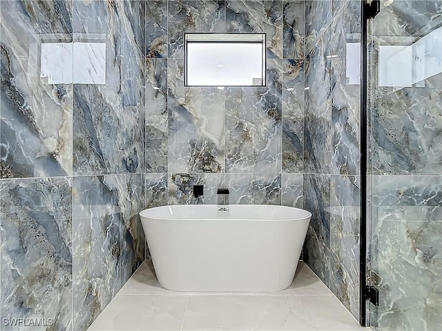 323 NE 19th Ter, Cape Coral, FL 33909 - full bathroom with tile walls, marble tiled flooring, and a soaking tub