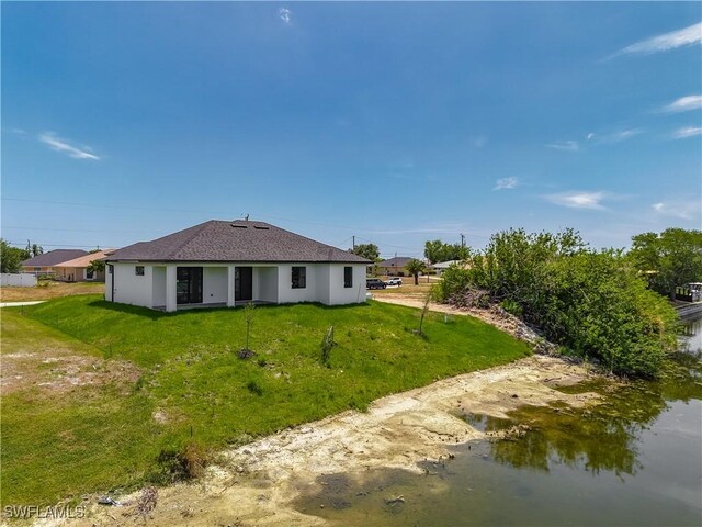323 NE 19th Ter, Cape Coral, FL 33909 - rear view of property with a lawn, roof with shingles, and stucco siding