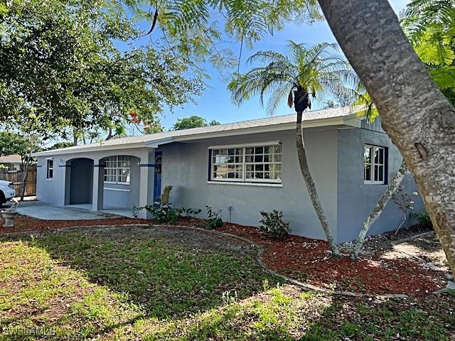 521 Pennview Ave, Lehigh Acres, FL 33936 - single story home with stucco siding, a patio, and fence
