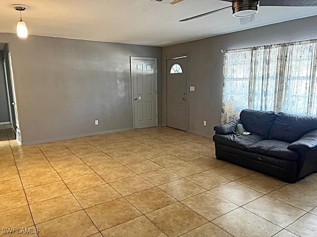 521 Pennview Ave, Lehigh Acres, FL 33936 - entrance foyer with plenty of natural light, light tile patterned flooring, and baseboards