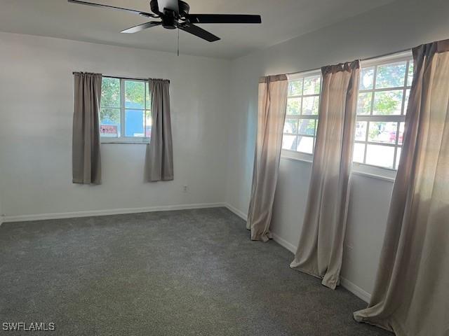 521 Pennview Ave, Lehigh Acres, FL 33936 - spare room with a ceiling fan, dark colored carpet, and baseboards