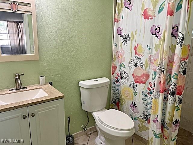 521 Pennview Ave, Lehigh Acres, FL 33936 - bathroom featuring toilet, tile patterned floors, vanity, a textured wall, and curtained shower