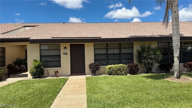 3916 SE 11th Pl Unit 503, Cape Coral, FL 33904 - view of front of property featuring roof with shingles, a front yard, and stucco siding