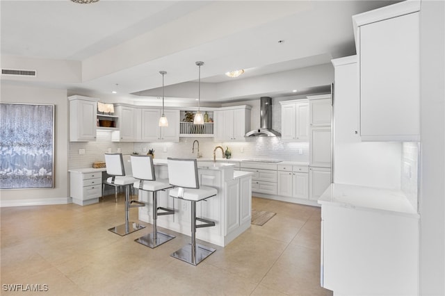 14270 Royal Harbour Ct Unit 920, Fort Myers, FL 33908 - kitchen featuring wall chimney range hood, open shelves, a tray ceiling, a breakfast bar, and decorative backsplash
