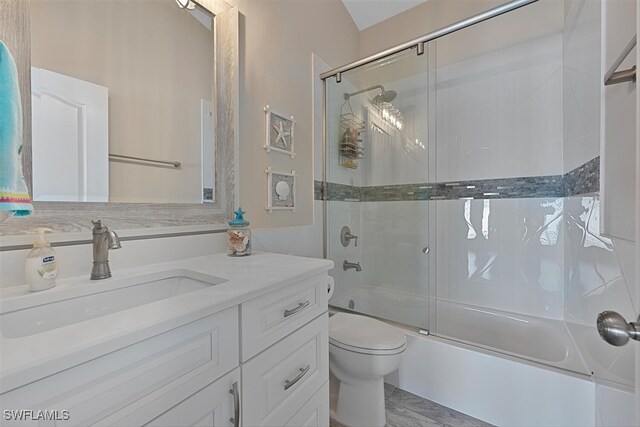 607 92nd Ave N, Naples, FL 34108 - bathroom with combined bath / shower with glass door, vanity, and toilet