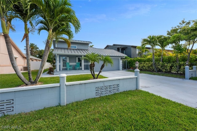 607 92nd Ave N, Naples, FL 34108 - view of front of house with driveway, a standing seam roof, covered porch, a garage, and metal roof