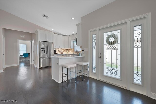 607 92nd Ave N, Naples, FL 34108 - kitchen with stainless steel fridge with ice dispenser, light countertops, a peninsula, a kitchen breakfast bar, and decorative backsplash