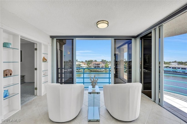 255 Park Shore Dr Unit 3-341, Naples, FL 34103 - dining room with a wall of windows, a water view, a textured ceiling, and light tile patterned floors