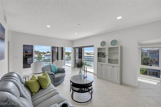 255 Park Shore Dr Unit 3-341, Naples, FL 34103 - living room with a textured ceiling, recessed lighting, light tile patterned flooring, and baseboards