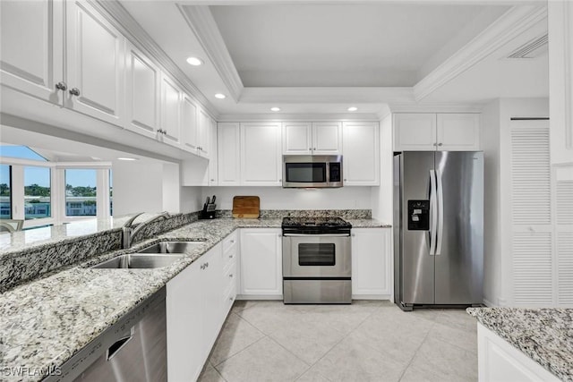 255 Park Shore Dr Unit 3-341, Naples, FL 34103 - kitchen featuring stainless steel appliances, a sink, a raised ceiling, white cabinetry, and light tile patterned floors