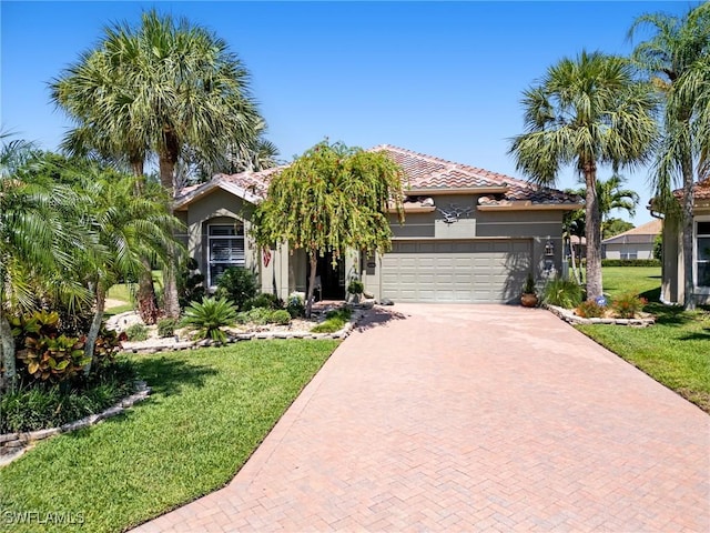 13708 Collina Ct, Estero, FL 33928 - view of front of house with decorative driveway, an attached garage, a front yard, and stucco siding