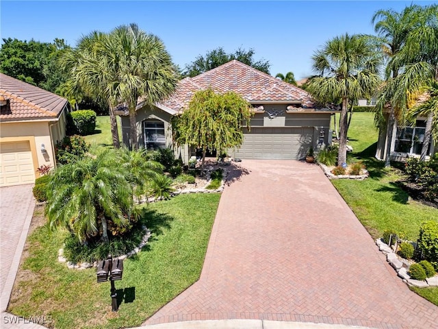 13708 Collina Ct, Estero, FL 33928 - view of front of home with decorative driveway, stucco siding, a front yard, and an attached garage