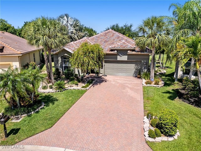 13708 Collina Ct, Estero, FL 33928 - view of front facade with decorative driveway, a garage, stucco siding, and a front yard