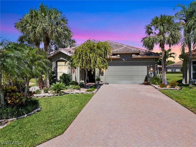 13708 Collina Ct, Estero, FL 33928 - view of front of home with decorative driveway, a garage, a front yard, and stucco siding