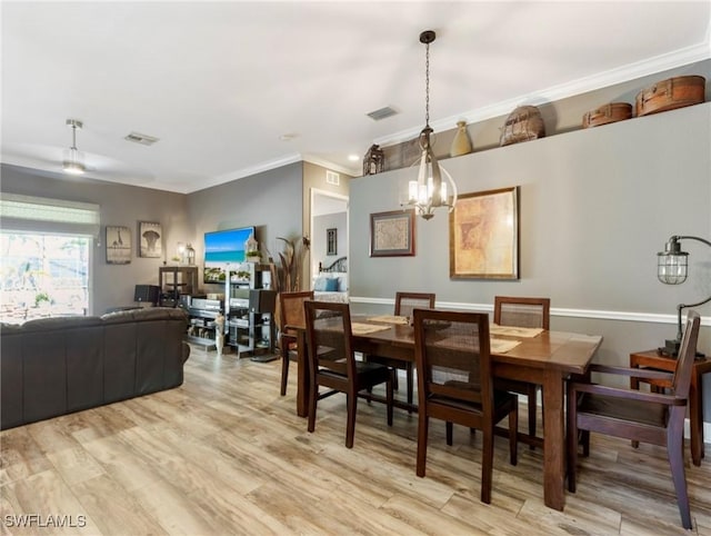 13708 Collina Ct, Estero, FL 33928 - dining area featuring a chandelier, light wood-style flooring, and crown molding