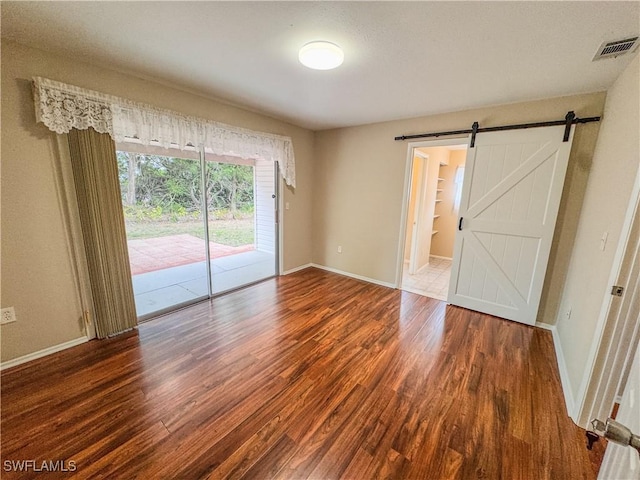 2016 Mariner Ct, Labelle, FL 33935 - empty room featuring wood finished floors, baseboards, and a barn door