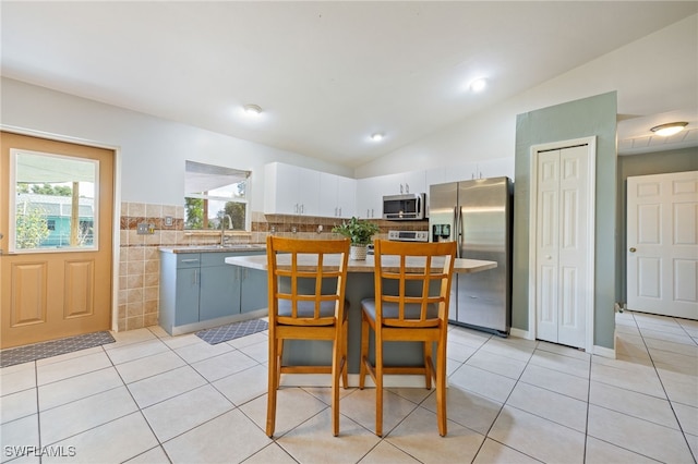 227 Manasota St, Fort Myers, FL 33913 - kitchen featuring appliances with stainless steel finishes, vaulted ceiling, light countertops, white cabinetry, and healthy amount of natural light