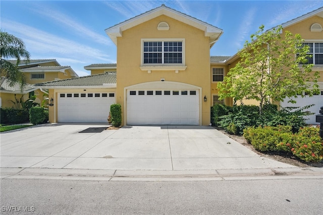 8380 Big Acorn Cir Unit 12A, Naples, FL 34119 - view of front facade featuring concrete driveway, stucco siding, an attached garage, and a tiled roof