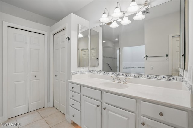 8380 Big Acorn Cir Unit 12A, Naples, FL 34119 - bathroom with a closet, a shower stall, tile patterned floors, vanity, and a chandelier