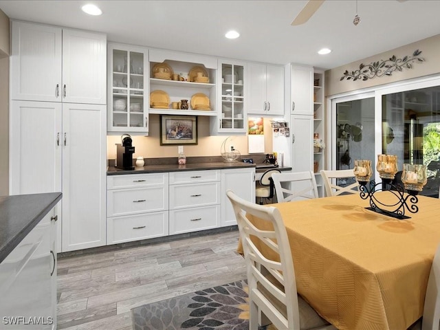 112 Marco Villas Dr Unit U2, Marco Island, FL 34145 - kitchen featuring open shelves, white cabinets, dark countertops, light wood-type flooring, and recessed lighting