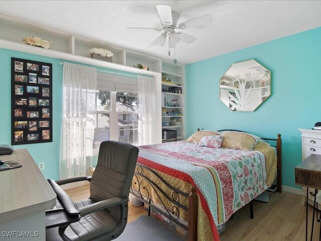 112 Marco Villas Dr Unit U2, Marco Island, FL 34145 - bedroom with wood finished floors, an office area, a textured ceiling, and a ceiling fan