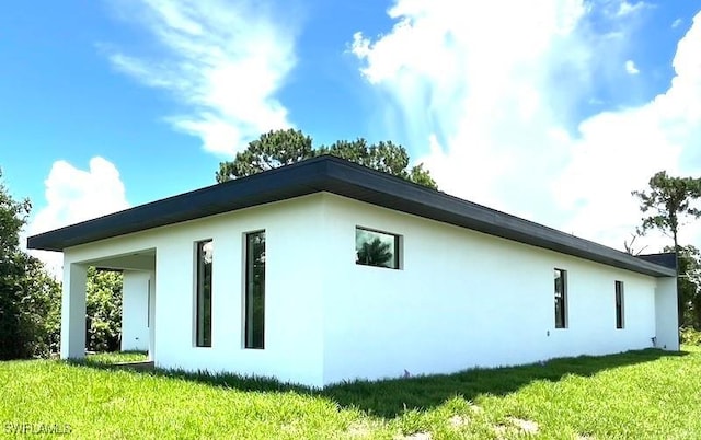 1218 Eclat St E, Lehigh Acres, FL 33974 - view of home's exterior featuring stucco siding and a yard