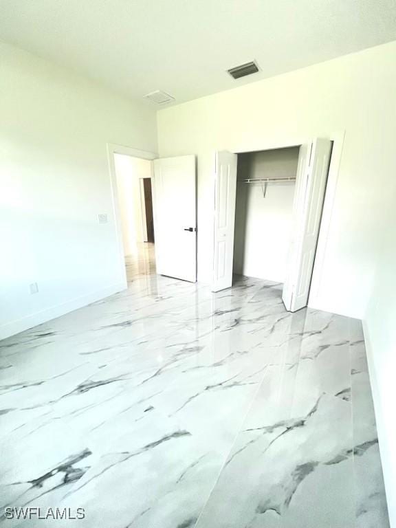 1218 Eclat St E, Lehigh Acres, FL 33974 - unfurnished bedroom with light marble finish floors and a closet
