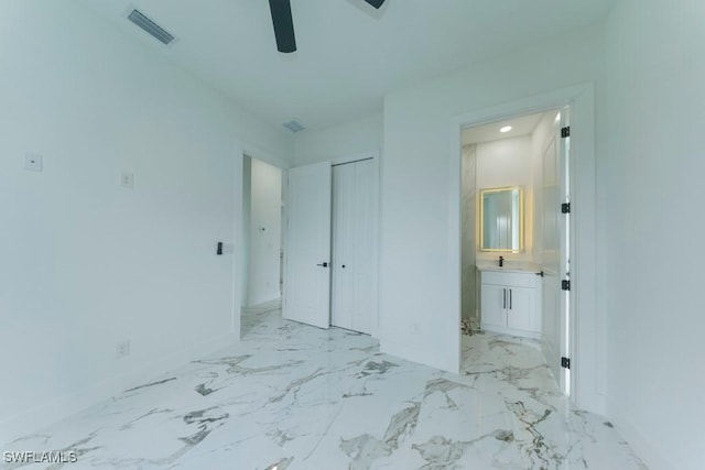 341 NE 31st Ter, Cape Coral, FL 33909 - unfurnished bedroom featuring baseboards, ensuite bath, a closet, marble finish floors, and a sink
