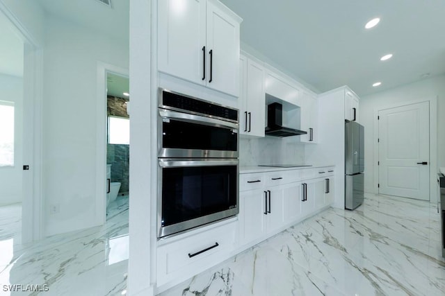 341 NE 31st Ter, Cape Coral, FL 33909 - kitchen featuring appliances with stainless steel finishes, wall chimney exhaust hood, recessed lighting, white cabinetry, and light marble finish flooring