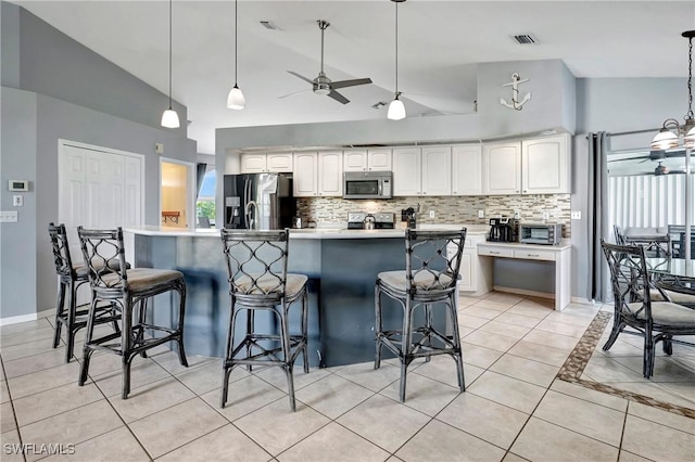 2128 SW 8th Ct, Cape Coral, FL 33991 - kitchen with stainless steel appliances, a ceiling fan, light tile patterned flooring, backsplash, and high vaulted ceiling