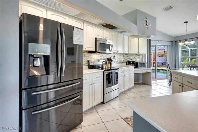 2128 SW 8th Ct, Cape Coral, FL 33991 - kitchen with appliances with stainless steel finishes, decorative backsplash, vaulted ceiling, hanging light fixtures, and a chandelier