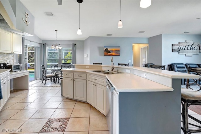 2128 SW 8th Ct, Cape Coral, FL 33991 - kitchen with a sink, a chandelier, light countertops, dishwasher, and a kitchen bar