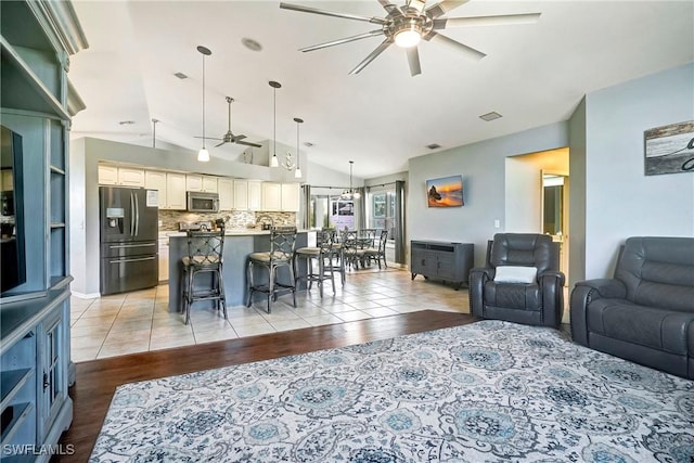 2128 SW 8th Ct, Cape Coral, FL 33991 - living area with a ceiling fan, vaulted ceiling, and light wood-style floors
