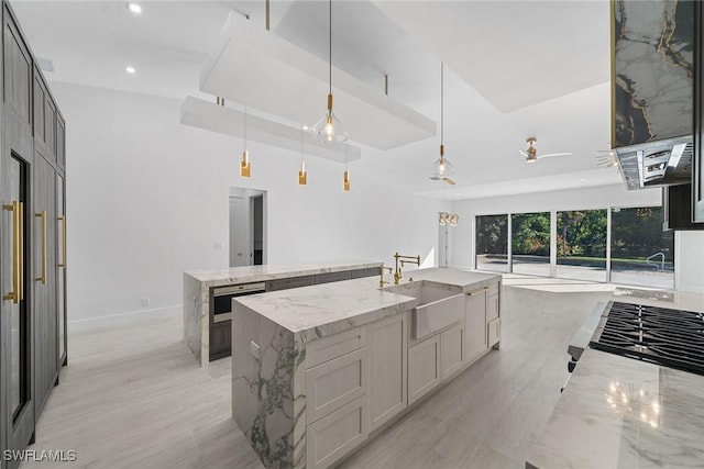 4440 15th Ave SW, Naples, FL 34116 - kitchen with a large island, a sink, recessed lighting, light stone counters, and decorative light fixtures
