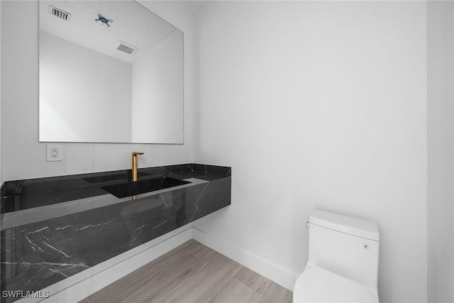 4440 15th Ave SW, Naples, FL 34116 - bathroom with toilet, a sink, baseboards, and wood finished floors