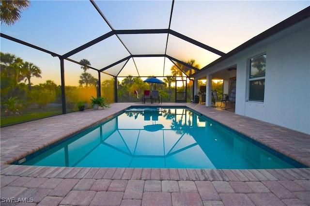 2640 36th Ave SE, Naples, FL 34117 - pool at dusk featuring a patio, an outdoor pool, and glass enclosure