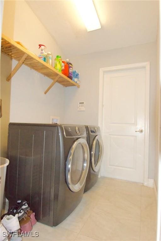 2640 36th Ave SE, Naples, FL 34117 - clothes washing area with light tile patterned floors and washing machine and clothes dryer